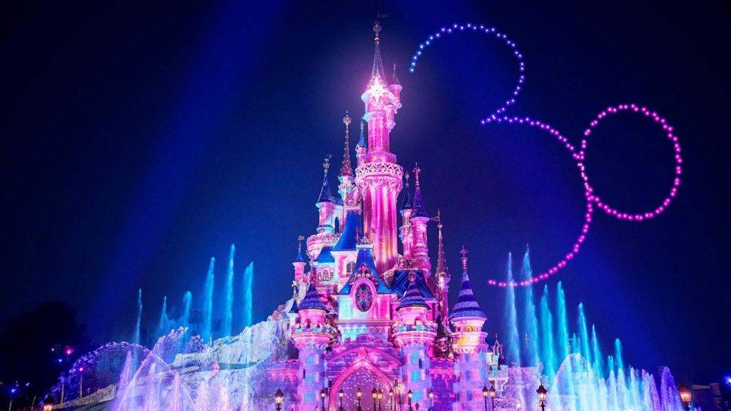 Castillo de Disneyland Paris iluminado de noche durante el espectáculo Disney Dreams